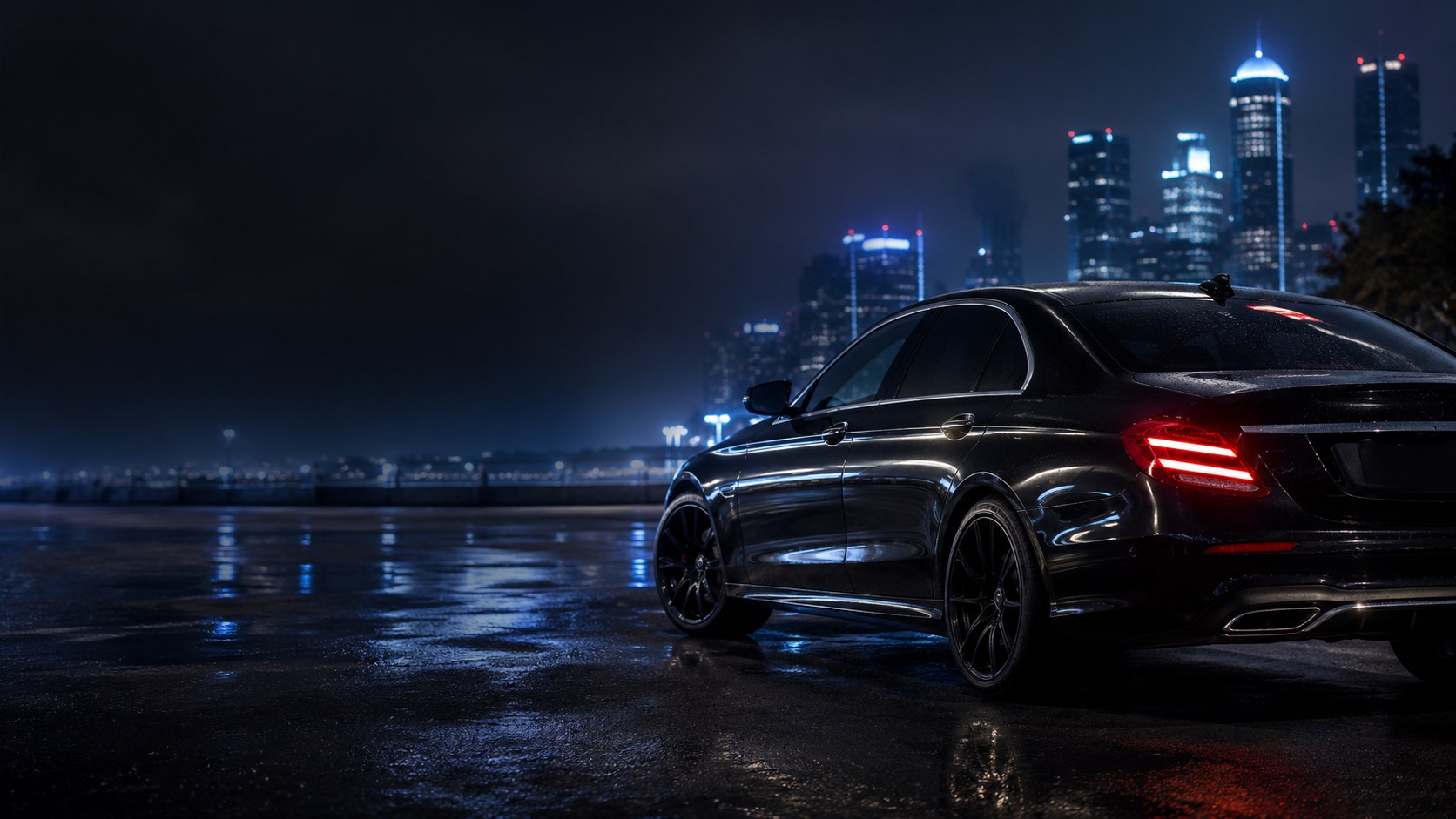 Premium black car at night with city lights